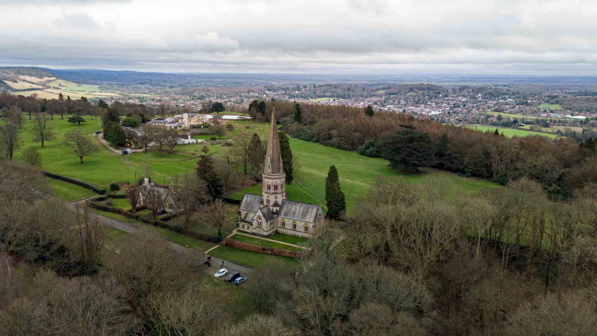 View of the stunning North Downs Escarpment, featuring lush green fields, the iconic Victorian church with its spire rising gracefully, and panoramic views of the surrounding countryside. A perfect blend of history and nature, making this area a must-visi