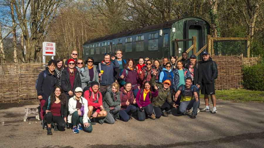 Espartans hiking group gathering after a successful adventure near a historic train carriage