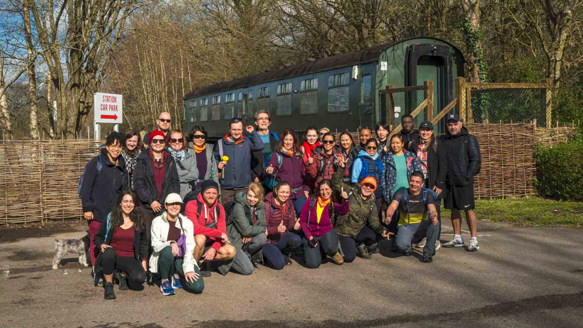 Espartans hiking group gathering after a successful adventure near a historic train carriage