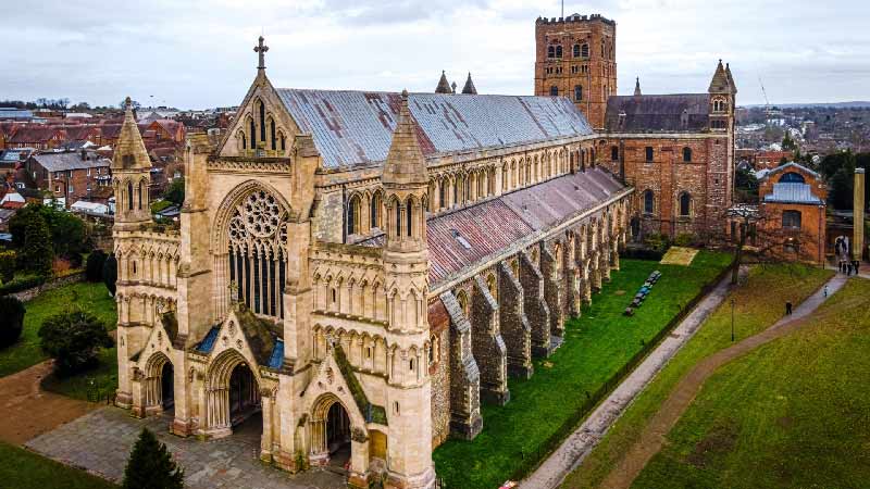 Aerial view of St Albans Abbey in Hertfordshire, UK, showcasing its magnificent medieval architecture and surrounding landscape.